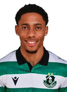 Shamrock Rovers football player in team kit, smiling, Irish club logo visible.