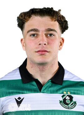 Young male football player in Shamrock Rovers jersey, close-up portrait, team logo visible, focused.