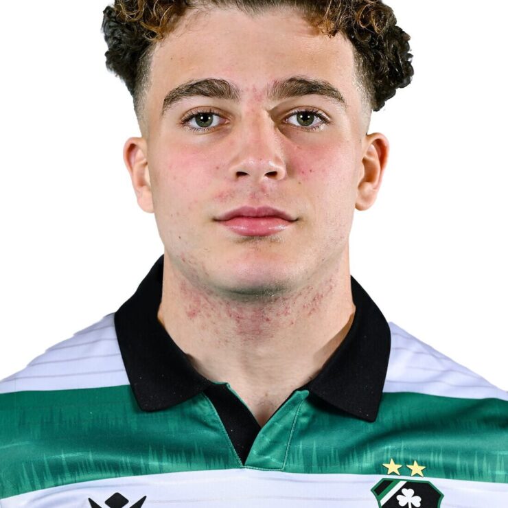 Young male football player in Shamrock Rovers jersey, close-up portrait, team logo visible, focused.