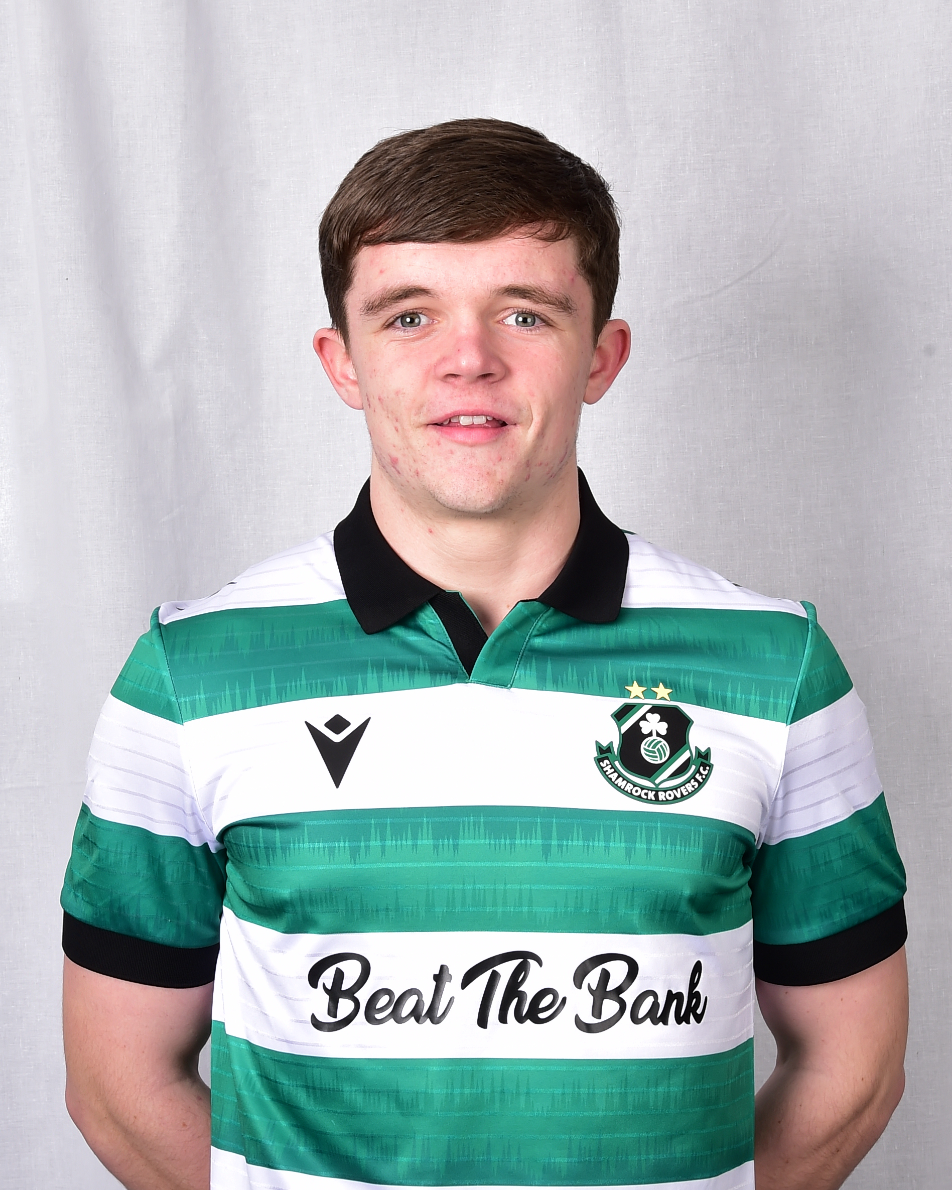 Josh Delves in Shamrock Rovers football kit, smiling for team photo.