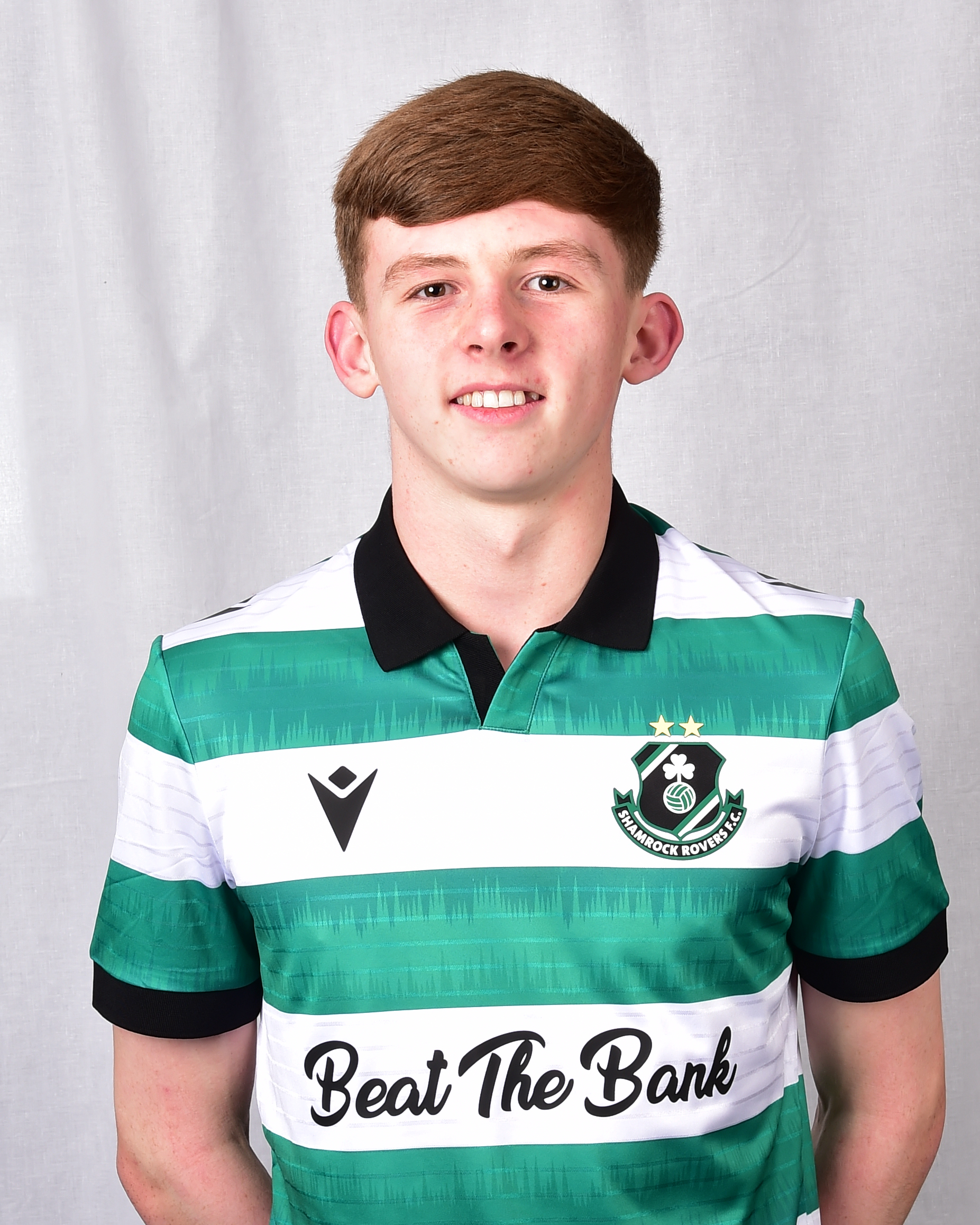 Shamrock Rovers player Danny Burke wearing team jersey with club crest and "Beat The Bank" sponsor.