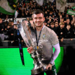 Shamrock Rovers player celebrating with trophy after winning Irish Premier Division title.