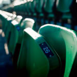 Empty green stadium seats at Tallaght Stadium, home of Shamrock Rovers, with sunlight casting shadows.