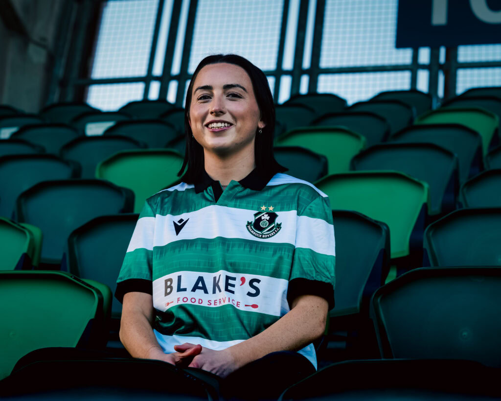 Shamrock Rovers football player in club jersey at stadium.