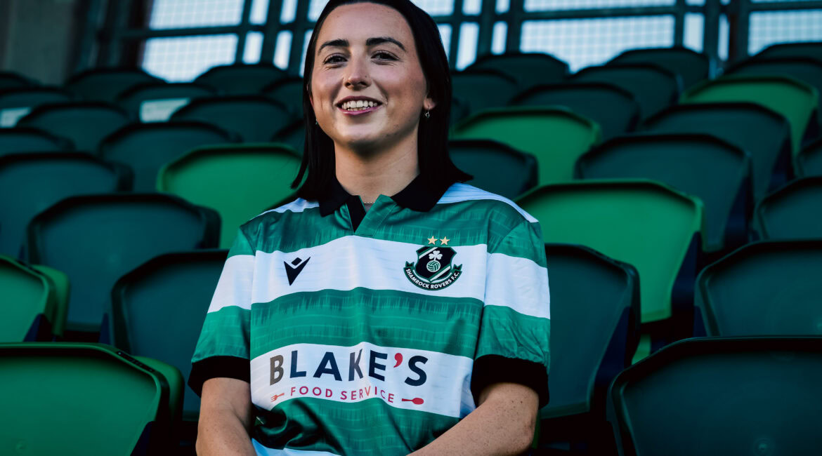 Shamrock Rovers football player in club jersey at stadium.