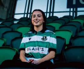 Shamrock Rovers football player in club jersey at stadium.