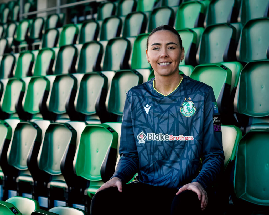 Shamrock Rovers female player smiling in team jersey at Tallaght Stadium.
