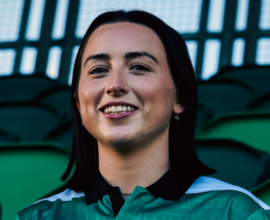 Shamrock Rovers female football player in team jersey at Tallaght Stadium.