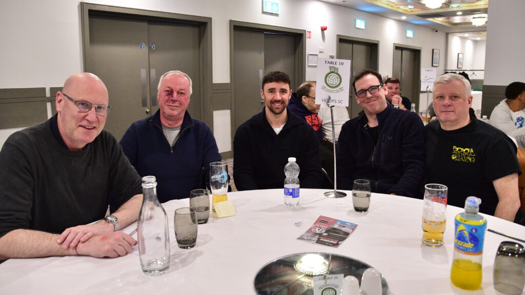 Happy group of men enjoying a dinner event at Shamrock Rovers football club, showcasing team spirit and camaraderie.