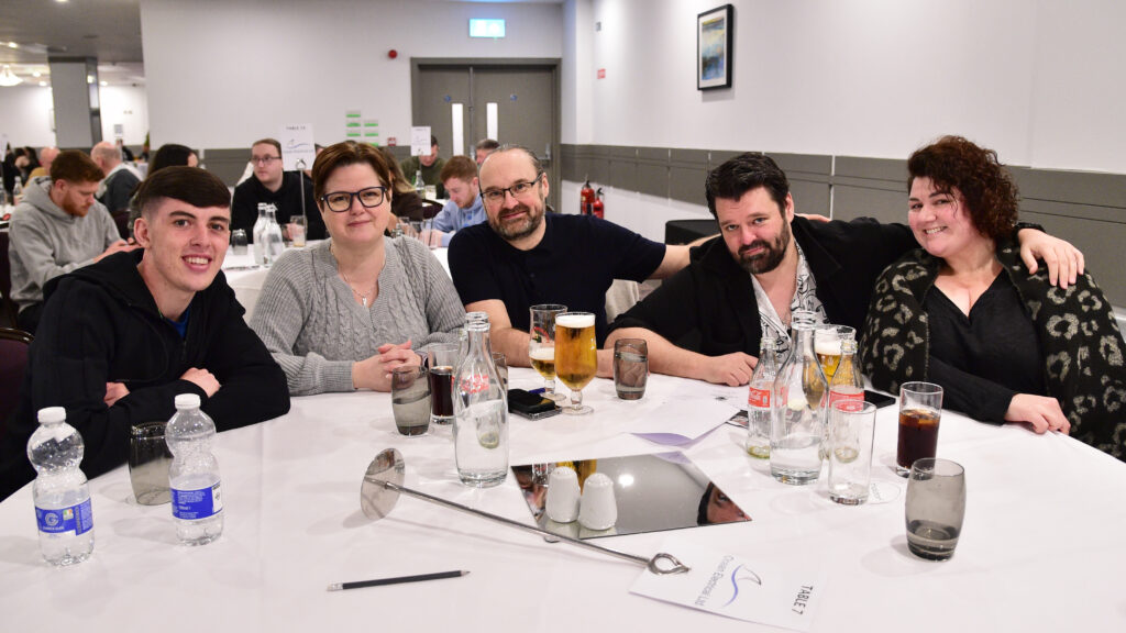 Close-up of Shamrock Rovers fans celebrating at a football match in Ireland. Focus on team supporters enjoying the game.