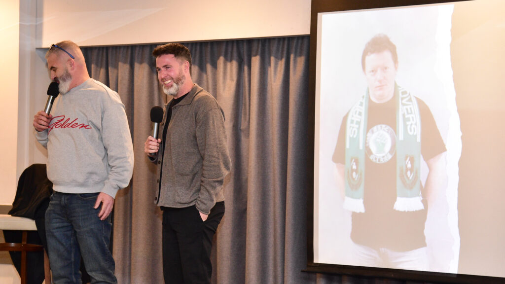 Legendary Shamrock Rovers football players and fans at a club event, celebrating Irish football history and club achievements.
