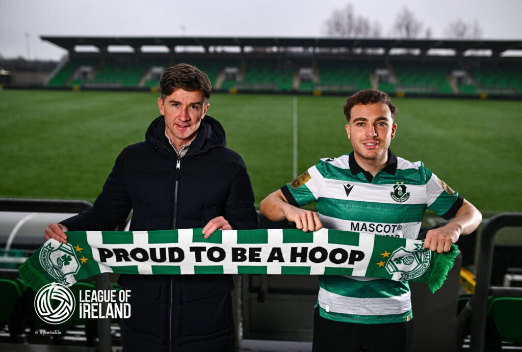 Proud Shamrock Rovers fan holding scarf at Tallaght Stadium, Dublin.