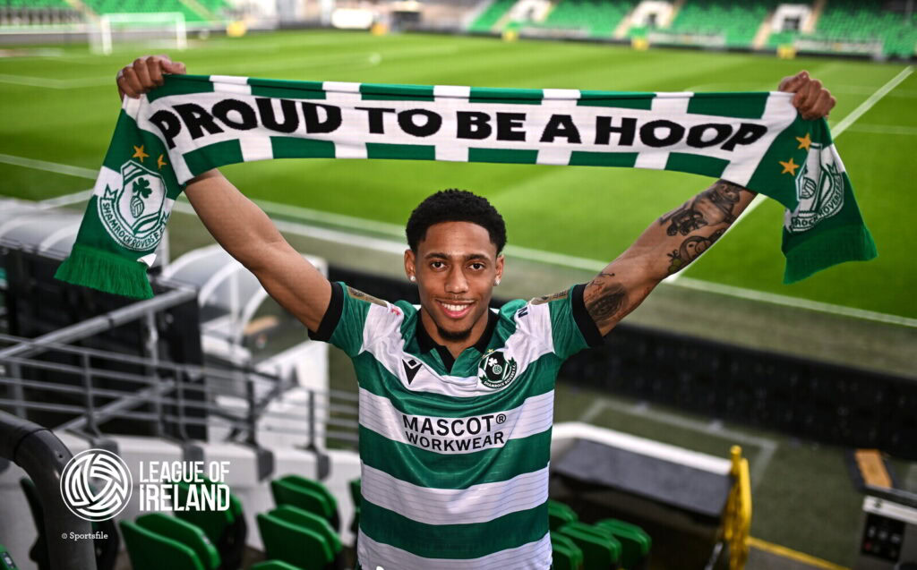 Proud Shamrock Rovers player holding a scarf in the stadium.