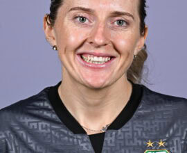 Shamrock Rovers female player smiling in team jersey, close-up portrait.