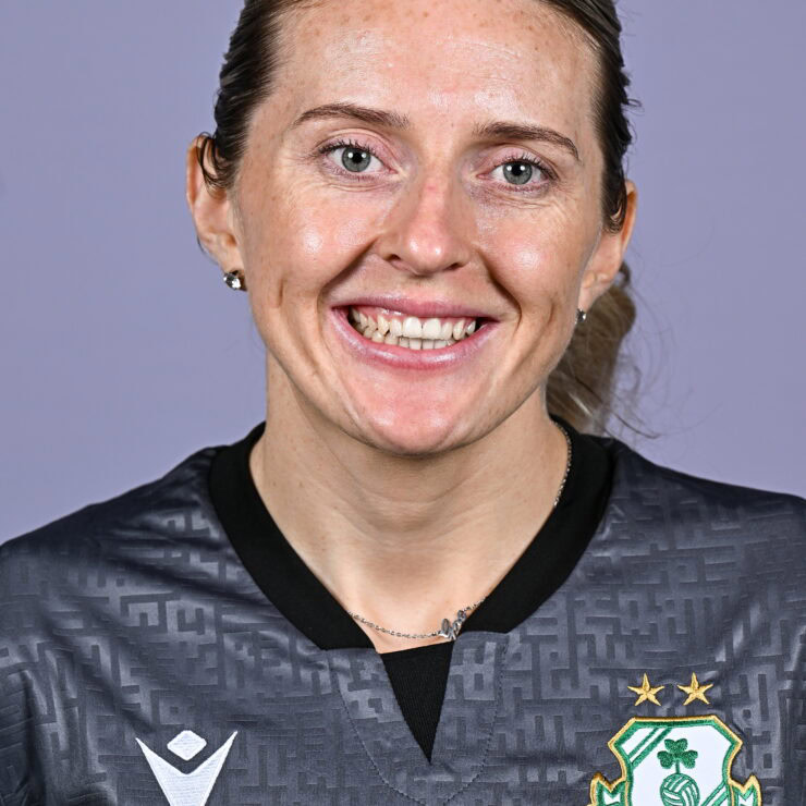 Shamrock Rovers female player smiling in team jersey, close-up portrait.