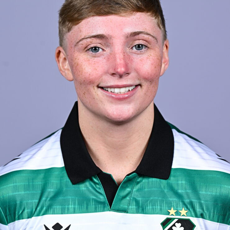 Female Shamrock Rovers player in team jersey smiling at camera.