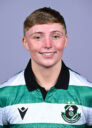 Female Shamrock Rovers player in team jersey smiling at camera.