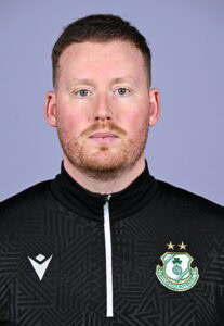 Shamrock Rovers football player in team kit, facing forward, with club crest visible.