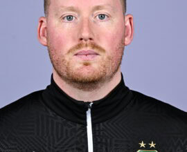 Shamrock Rovers football player in team kit, facing forward, with club crest visible.