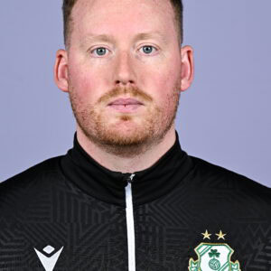 Shamrock Rovers football player in team kit, facing forward, with club crest visible.