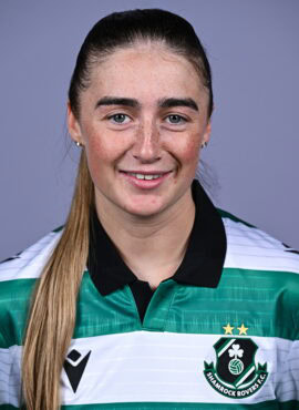 Female Shamrock Rovers player in team jersey smiling at camera.