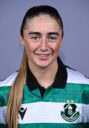 Female Shamrock Rovers player in team jersey smiling at camera.