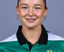 Female football player in Shamrock Rovers jersey smiling.