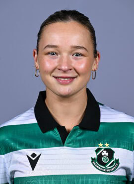 Female football player in Shamrock Rovers jersey smiling.
