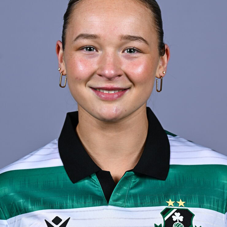 Female football player in Shamrock Rovers jersey smiling.