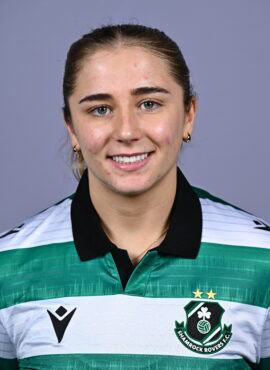 Female Shamrock Rovers player smiling in team jersey.