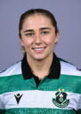 Female Shamrock Rovers player smiling in team jersey.