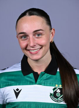 Female Shamrock Rovers player smiling in team jersey.