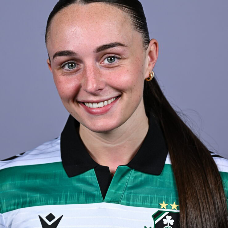 Female Shamrock Rovers player smiling in team jersey.