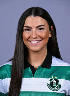 Female football player in Shamrock Rovers jersey smiling.