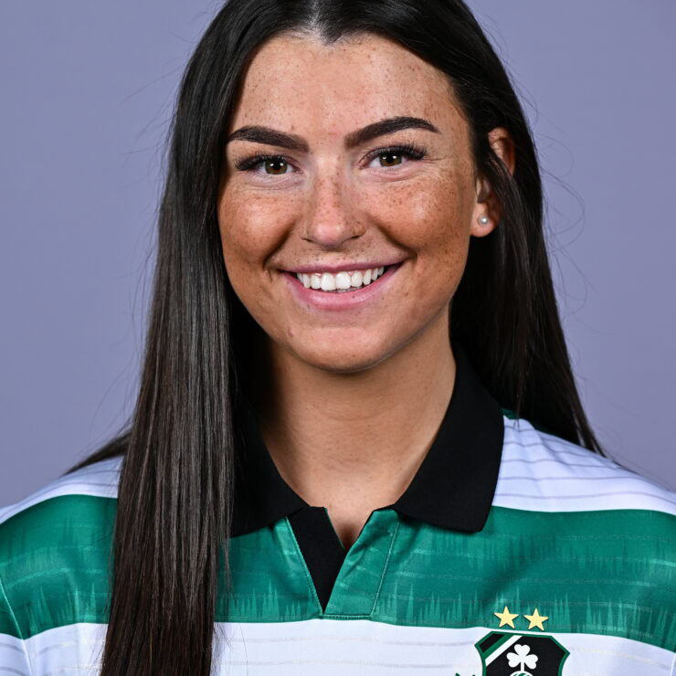 Female football player in Shamrock Rovers jersey smiling.