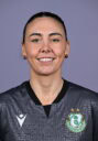 Female Shamrock Rovers player smiling in team jersey.
