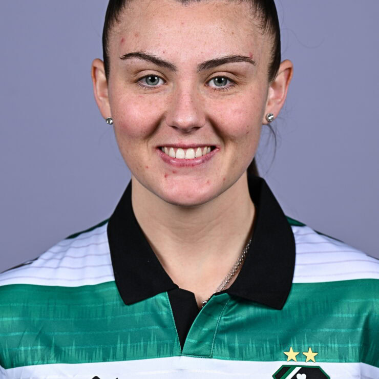 Female Shamrock Rovers player smiling in team jersey.
