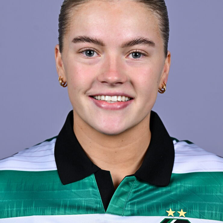 Shamrock Rovers female football player smiling in team jersey.