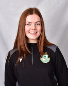Female football player in Shamrock Rovers kit smiling.