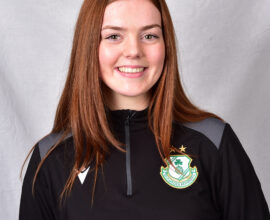 Female football player in Shamrock Rovers kit smiling.