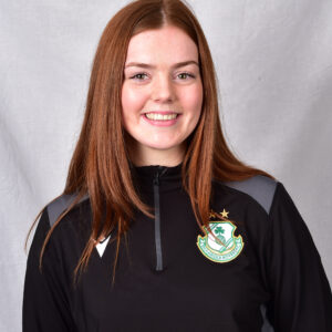 Female football player in Shamrock Rovers kit smiling.