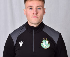 Shamrock Rovers player in team kit with club crest, facing camera.