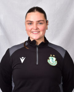Female Shamrock Rovers player smiling in team kit.