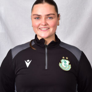Female Shamrock Rovers player smiling in team kit.