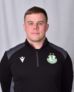Shamrock Rovers player in team kit with club crest, facing forward.