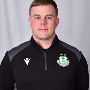 Shamrock Rovers player in team kit with club crest, facing forward.