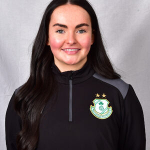 Female Shamrock Rovers player in team kit smiling at camera.