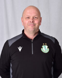 Shamrock Rovers coach in team jacket, smiling, standing against a plain background.