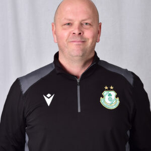 Shamrock Rovers coach in team jacket, smiling, standing against a plain background.