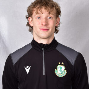Young Shamrock Rovers player in team training kit, smiling at camera.